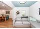 Bright living room with a gray sectional couch and blue ceiling, opening to the dining room at 8562 N Highway 17, McClellanville, SC 29458