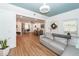 Bright living room with a gray sectional couch, wood floors, opening to the dining room and kitchen at 8562 N Highway 17, McClellanville, SC 29458