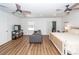 Spacious main bedroom with a sofa, television, hardwood floors, and two ceiling fans at 8562 N Highway 17, McClellanville, SC 29458