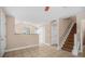 Spacious living area showcasing neutral tones and tile flooring, complemented by an open staircase at 8743 Grassy Oak Trl, North Charleston, SC 29420