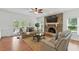 Bright living room with a brick fireplace, large windows, and comfortable leather sofas at 910 Kushiwah Creek Ct, Charleston, SC 29412