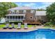 Gorgeous backyard featuring a sparkling pool, lounge chairs, and a well-maintained lawn and brick home at 910 Kushiwah Creek Ct, Charleston, SC 29412