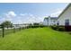 Expansive backyard with a well-maintained lawn and serene lake view beyond a black metal fence at 103 Savannah River Dr, Summerville, SC 29485