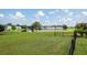 Large, well-maintained lawn with decorative black metal fence and pond view at 103 Savannah River Dr, Summerville, SC 29485