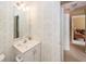 Well-lit bathroom features a vanity sink, neutral wallpaper, and doorway access at 103 Savannah River Dr, Summerville, SC 29485