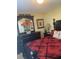 Comfortable bedroom with a red and black patterned bedspread and black dresser with flower arrangement, exuding charm at 103 Savannah River Dr, Summerville, SC 29485