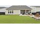 Large manicured backyard featuring a stone fire pit, comfortable seating, and a covered patio at 109 Medford St, Summerville, SC 29486