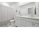 Bathroom featuring double sinks, framed mirror, white cabinets, and a checkered shower curtain at 109 Medford St, Summerville, SC 29486