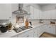 Bright kitchen with white cabinetry, quartz countertops, and a stainless steel range hood at 109 Medford St, Summerville, SC 29486