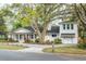 Inviting two-story home boasts a charming front porch, fresh white siding, a prominent shade tree, and a well-kept lawn at 1106 Meadowcroft Ln, Mount Pleasant, SC 29464