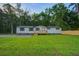 Classic one-story home with a charming wooden deck and freshly cut lawn, providing a cozy and inviting atmosphere at 117 Dairy Ln, Cottageville, SC 29435