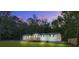 Charming single-story home with a wooden deck, surrounded by a lush lawn and serene forest backdrop at twilight at 117 Dairy Ln, Cottageville, SC 29435