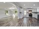 Bright, open-concept living and kitchen area with luxury vinyl plank flooring, white cabinets, and modern finishes at 117 Dairy Ln, Cottageville, SC 29435