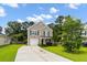 Charming two-story home with a well-maintained lawn and driveway, complemented by lush green trees and landscaping at 1170 Deerberry Rd, Hanahan, SC 29410
