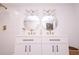 Modern bathroom with double vanity, white cabinets, black hardware, and elegant round mirrors at 1211 Lem Rd, Cordesville, SC 29434