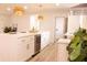 Bright, modern kitchen with white cabinets, quartz countertops, wine fridge, and decorative wicker light fixtures at 1211 Lem Rd, Cordesville, SC 29434