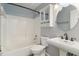 Bathroom features a tub with shower, white tile, storage cabinet, and pedestal sink at 1245 Lakefront Drive Dr, Charleston, SC 29412