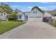 Charming light blue two-story home with attached two-car garage, well-maintained lawn, and sunny skies at 1245 Lakefront Drive Dr, Charleston, SC 29412