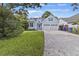 Charming light blue home with attached two-car garage, well-manicured lawn, and blue skies at 1245 Lakefront Drive Dr, Charleston, SC 29412