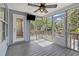 Inviting screened-in porch with TV, fan, and view of the private backyard and exterior door at 1245 Lakefront Drive Dr, Charleston, SC 29412