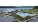Aerial view of a community pool and clubhouse with ample seating and parking, with a lake in the background at 125 Beam St, Huger, SC 29450