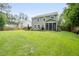 Inviting backyard featuring lush lawn, patio area, and charming screened porch, perfect for entertaining at 125 Beam St, Huger, SC 29450