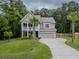 Charming two-story home with a landscaped lawn, two-car garage, and welcoming front porch at 125 Beam St, Huger, SC 29450
