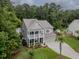 An elevated view of a gray two-story house featuring a welcoming porch and a well-maintained lawn at 125 Beam St, Huger, SC 29450