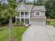 Elegant two-story home showcasing a spacious driveway, well-manicured lawn and double stacked porches at 125 Beam St, Huger, SC 29450
