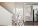 Bright hallway featuring hardwood floors, white trim and cabinetry, leading to a sunlit front door at 125 Beam St, Huger, SC 29450