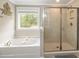 Bright main bathroom with a soaking tub and glass-enclosed shower offers a relaxing retreat at 125 Beam St, Huger, SC 29450