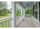 Covered porch with wood floors, white railings, and wooded views at 125 Beam St, Huger, SC 29450