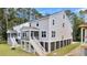 Side view of gray home with a screened porch, white stairs, and lush greenery at 1304 Lieben Rd, Mount Pleasant, SC 29466