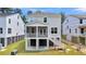 Rear view of raised gray home with a screened porch and white stairs at 1304 Lieben Rd, Mount Pleasant, SC 29466