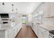 Bright kitchen featuring marble countertops, stainless steel appliances, and hardwood floors, with a view to the backyard at 143 Airy Dr, Summerville, SC 29486