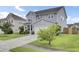 Charming two-story home featuring a well-manicured lawn and a long driveway leading to an attached garage at 145 Woodbrook Way, Moncks Corner, SC 29461