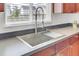 Close-up of stainless steel kitchen sink with a modern faucet and gray countertops at 145 Woodbrook Way, Moncks Corner, SC 29461