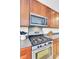Close-up of stainless steel range and microwave with gray countertops and wood cabinets at 145 Woodbrook Way, Moncks Corner, SC 29461