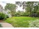Large grassy backyard with mature trees, hydrangeas, and access to a patio/deck, perfect for outdoor living at 1511 Fairway Dr, Charleston, SC 29412