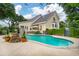 Backyard featuring a kidney-shaped pool, patio with dining set, and lush landscaping at 1511 Fairway Dr, Charleston, SC 29412
