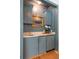 Stylish blue wet bar with marble countertop, gold hardware, and charming decor for elegant entertaining at 1511 Fairway Dr, Charleston, SC 29412