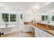 Bright bathroom featuring a soaking tub, granite countertops, and white cabinetry at 1511 Fairway Dr, Charleston, SC 29412
