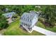 Elevated view of white two-story coastal home featuring verdant landscaping and a driveway at 1577 Periwinkle Dr, Mount Pleasant, SC 29466