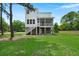 Exterior view of backyard showing white two-story home with screened porch and stairway at 1577 Periwinkle Dr, Mount Pleasant, SC 29466