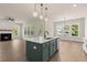 Kitchen with an open concept to the living room; features an island, lighting, hardwood floors and stainless appliances at 1577 Periwinkle Dr, Mount Pleasant, SC 29466