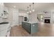 Open-concept kitchen featuring an island, stainless steel appliances and a view to the living room fireplace at 1577 Periwinkle Dr, Mount Pleasant, SC 29466