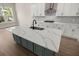 Modern kitchen featuring white cabinetry, quartz countertops, a black faucet and an island with a green base at 1577 Periwinkle Dr, Mount Pleasant, SC 29466