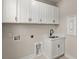 Well-lit laundry room with a sink, white cabinets, and light tile floors at 1577 Periwinkle Dr, Mount Pleasant, SC 29466