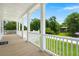 Inviting outdoor porch with wood flooring and white railing that overlooks the lawn at 1577 Periwinkle Dr, Mount Pleasant, SC 29466