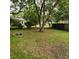Large backyard with a fire pit, mature trees, and a wood fence at 1601 Westmoreland Ave, Charleston, SC 29412